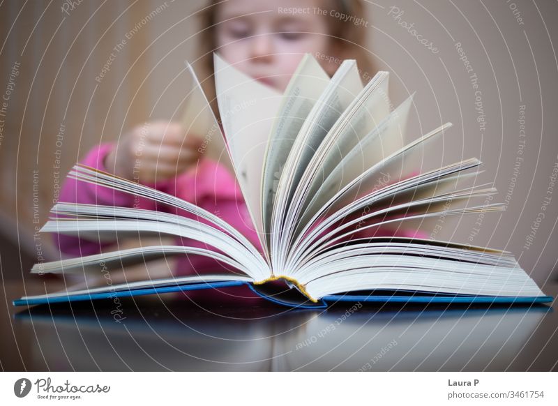 Kleines blondes Mädchen liest und macht Hausaufgaben bezaubernd achtsam aufmerksam schön Buch gelangweilt Kaukasier Kind Kindheit clever Nahaufnahme
