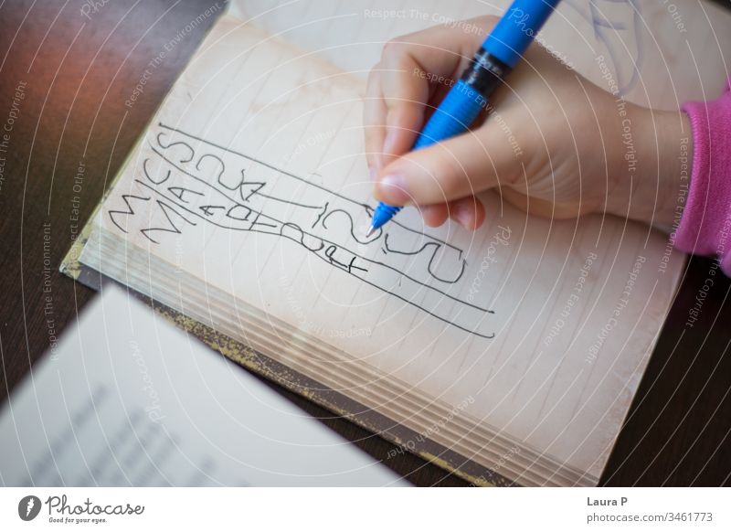 Nahaufnahme der Handschrift eines Kindes in einem Notizbuch bezaubernd achtsam aufmerksam schön blond Buch gelangweilt Kaukasier Kindheit clever konzentriert