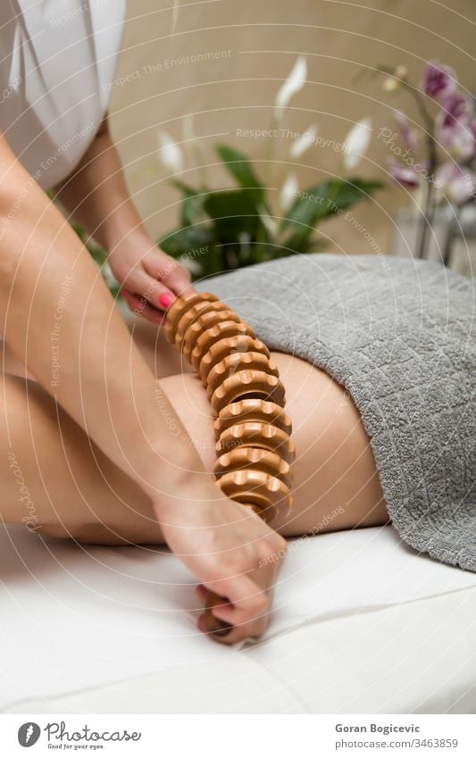 Maderotherapeutische Anti-Cellulite-Massage mit einem Massageroller aus Holz Erwachsener Körper Pflege tief Frau Hand Handgriff Gesundheit Bein Beine Lifestyle