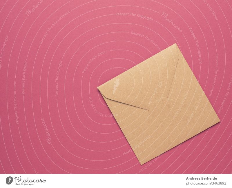 Ein Umschlag aus Recyclingpapier auf rotem Hintergrund mit Kopierfeld Kuvert Papier vereinzelt Brief Post blanko weiß Beitrag Nachricht Mitteilung Korrespondenz