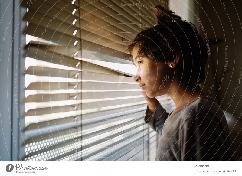 Neunjähriges Mädchen schaut durch die Jalousien aus dem Fenster zu Hause bleiben jung Frau heimwärts Quarantäne Person Gesicht Tag Raum Kaukasier schön Porträt