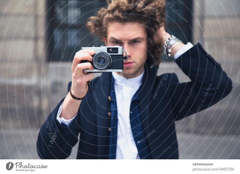 Junger Mann fotografiert mit einer alten Retrofilmkamera. Selektiver Fokus. Fotokamera altehrwürdig Hipster retro Ferien & Urlaub & Reisen Stil Tourist