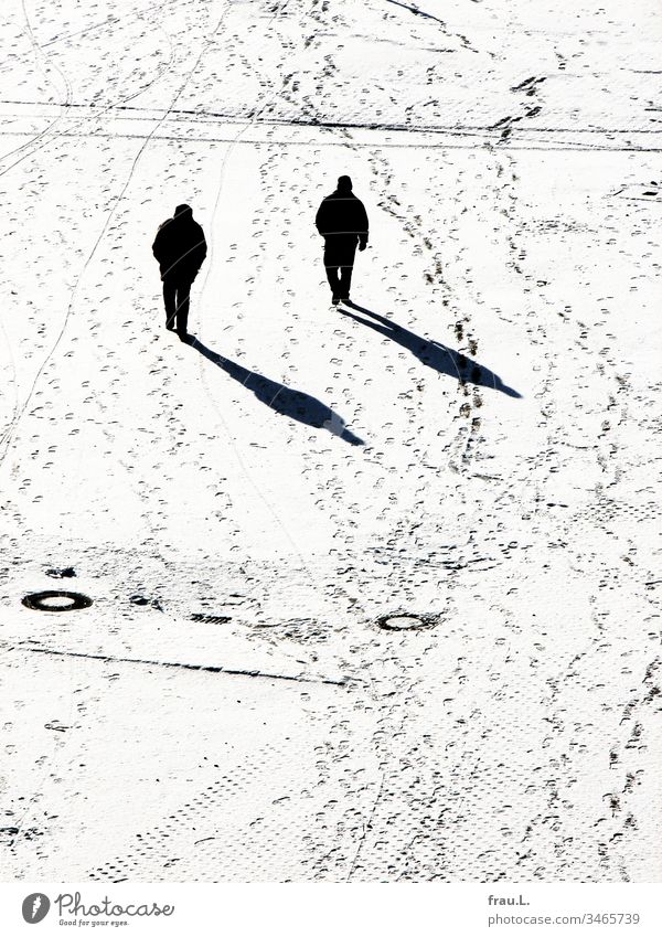 Wie geklont und sich doch fremd stapften die beiden Männer im Schnee aneinander vorbei. Winter Platz Mann Schwarzweißfoto kalt Spuren Schatten Sonnenlicht