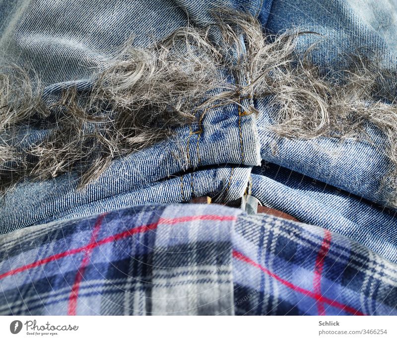 Die Haare sind ab und liegen auf dem Schoß, Coronafrisur Haare schneiden Jeans Detail Hose Nahaufnahme Hemd Bekleidung Vogelperspektive blau grau schwarz rot