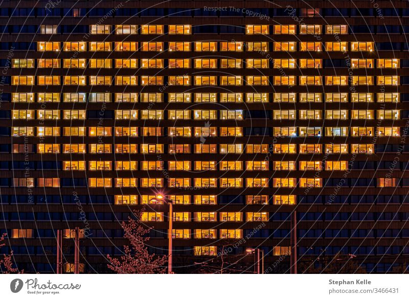 Herzförmige beleuchtete Fenster eines Gebäudes als Geste für Menschen, die andere unterstützen, wie jetzt in harten Coronavirus-Zeiten symbolisch. Form