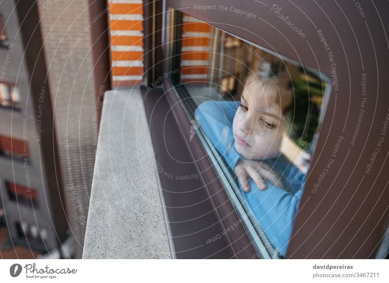 Trauriges Mädchen schaut aus dem Fenster traurig durch das Glas melancholisch Coronavirus Einsperrung covid-19 langweilig Traurigkeit durch das Fenster schauen