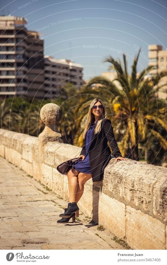 Junge glückliche Geschäftsfrau sitzt in der Stadt Erwachsener Teenager blond kolumbianisch Spanien Mädchen jung Frau attraktiv Tag stylisch elegant im Freien