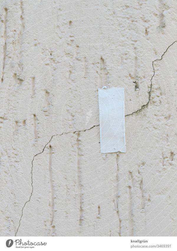 Ein Stück weißes Klebeband über einem Riss im Putz einer Hauswand Wand Schutz Mauer Fassade überklebt Rauputz Haarriss senkrecht Muster Strukturen & Formen