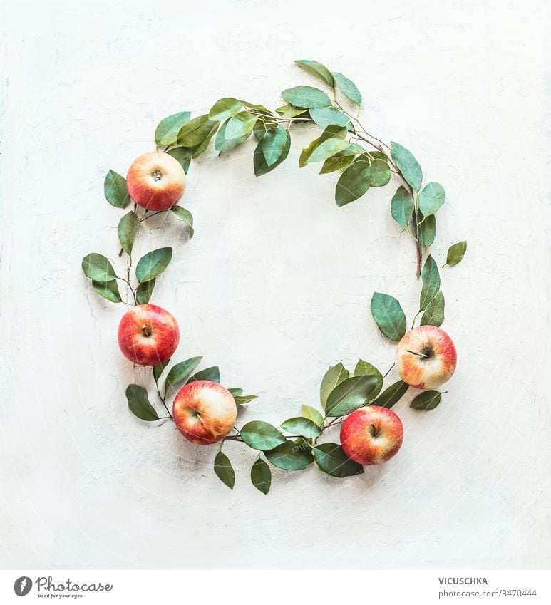 Schöner Kreisrahmen aus Äpfeln und grünen Blättern auf weißem Hintergrund. Kranz aus Früchten. Ernten . Apfel-Saison schön kreisen Rahmen gemacht Totenkranz