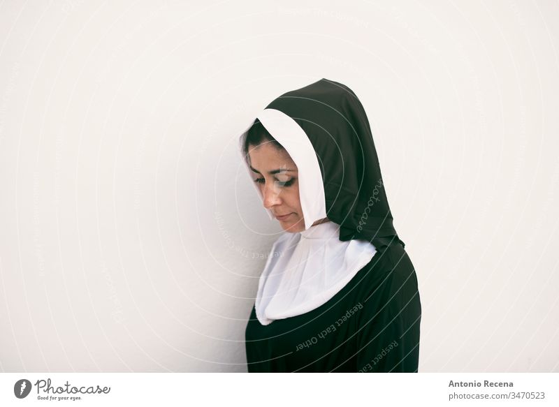 Nonne auf weißem Hintergrund mit Blick nach unten ernst Frau Religion Habitus Katholizismus 30s 40s Tracht Klischee hübsch attraktiv weißer Hintergrund