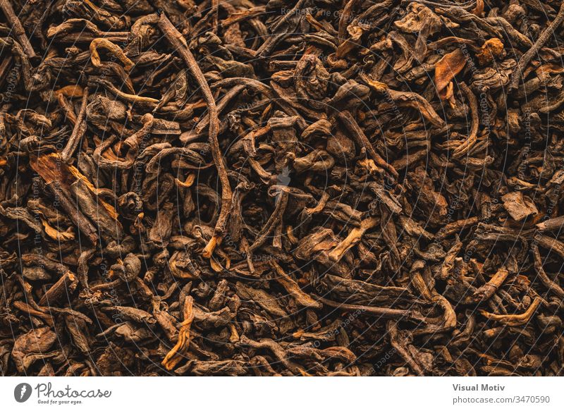 Nahaufnahme von getrockneten Schwarzteeblättern mit Zimt Tee Farbe Detailaufnahme Textur trinken Aufguss brauen im Innenbereich trocknen Blätter abstrakt