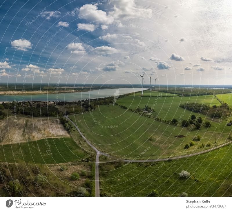 Alternative Energie - Räder eines Windgenerators im Lufthintergrund mit Feldern und einem See. Rad Natur Umwelt gewinnt alternativ grün Chance Himmel Antenne