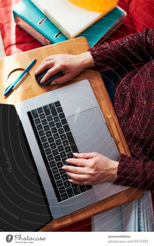 Mutter einer Frau, die während der COVID-19-Quarantäne während eines Video-Chat-Call-Stream-Online-Kurses auf einem Laptop von zu Hause aus ihren Job aus der Ferne erledigt. Frau sitzt im Bett vor dem Computer und schaut auf den Bildschirm