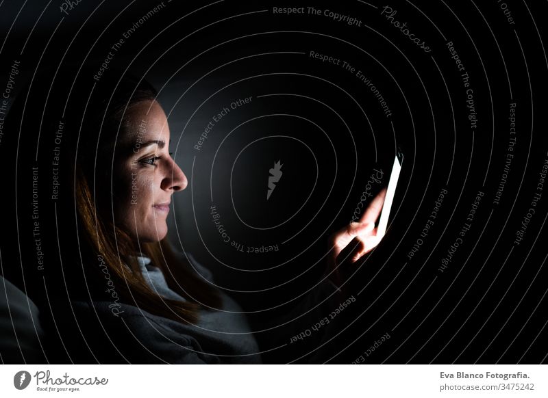 junge Frau zu Hause, die ein Mobiltelefon benutzt. Nachtzeit Handy heimwärts Bildschirm dunkel sich[Akk] entspannen Technik & Technologie Lifestyle Freizeit