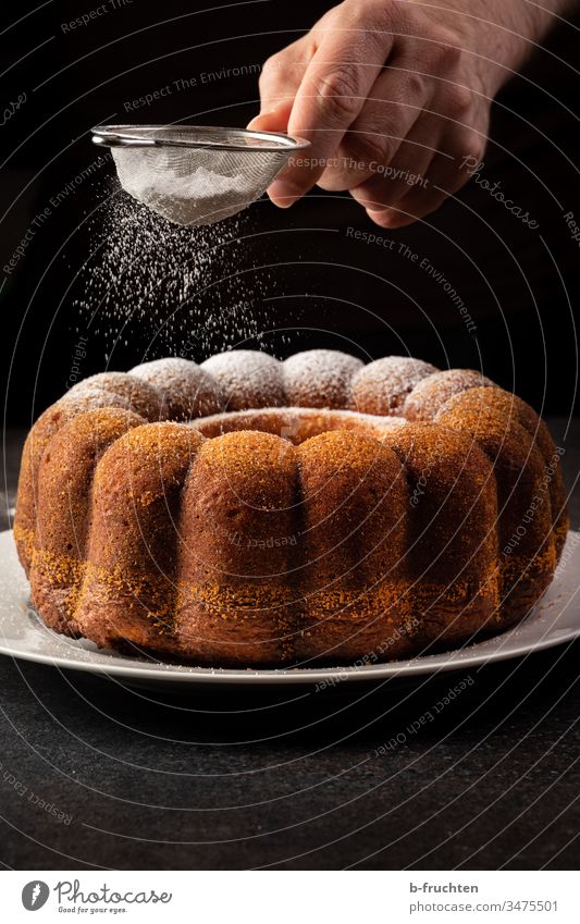 Kuchen mit Puderzucker bestreuen süß lecker Backwaren Süßigkeit Zucker staubzucker Hand Küche zubereiten zubereitung