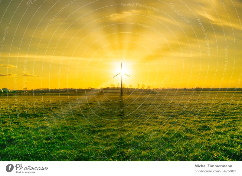 Windkraftanlage mit Biogasanlage im Sonnenschein/Sonnenauf-/untergang mit grünem Weidegras Sonnenaufgang Sonnenstrahlen Sonnenuntergang Sonnenlicht