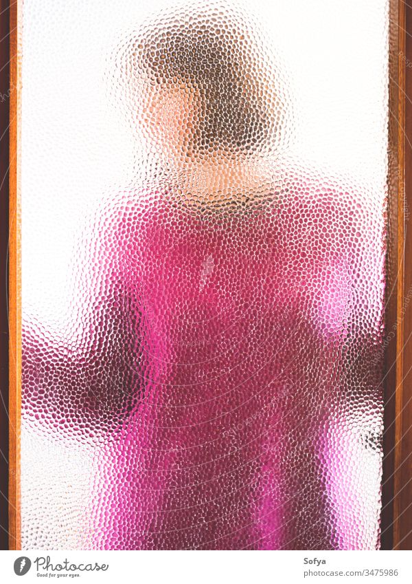 Junge Frau hinter verschlossener Tür durch Glas gesehen Mädchen zu Hause bleiben Fenster Silhouette rosa Pullover Winter gemütlich zugeklappt heimwärts