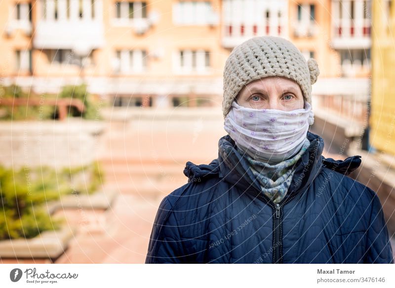 Eine arme ältere Frau trägt eine selbstgemachte Maske, um sich vor Viren zu schützen Erwachsener luftgestützt Atmung Gebäude Großstadt Ansteckung ansteckend