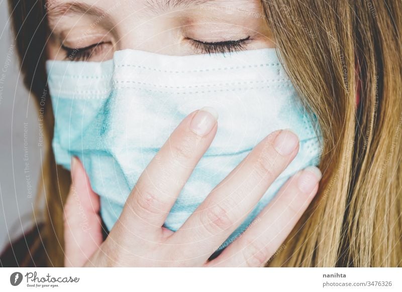 Junge Frau, die eine schützende Gesichtsmaske trägt Bund 19 COVID Grippe Mundschutz Coronavirus Pandemie Seuche Krankheit Atemwegserkrankungen soziale Distanz