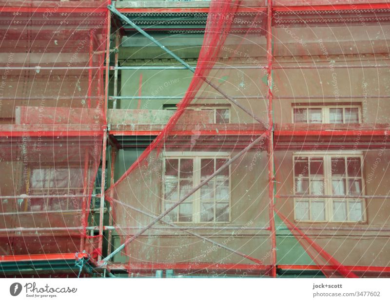 Renovierung der grünen Fassade mit rötlichen Baugerüst Baustelle Abdeckung authentisch Schutz Wandel & Veränderung Modernisierung Architektur Detailaufnahme