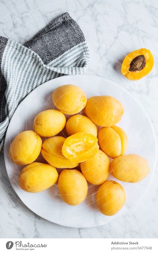 Teller mit frischen Aprikosen auf weißem Marmortisch Frucht reif Tisch gelb orange natürlich Lebensmittel lecker geschmackvoll Gesundheit organisch Bestandteil