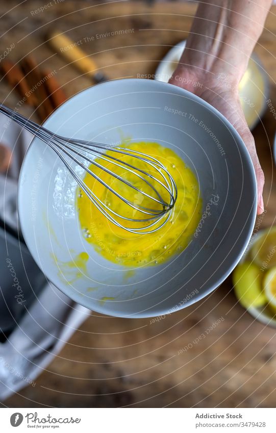Gesichtslose Frau bereitet Eier mit Schneebesen in der Küche zu Koch Bestandteil Schalen & Schüsseln Holztisch Prozess Lebensmittel vorbereiten frisch Rezept
