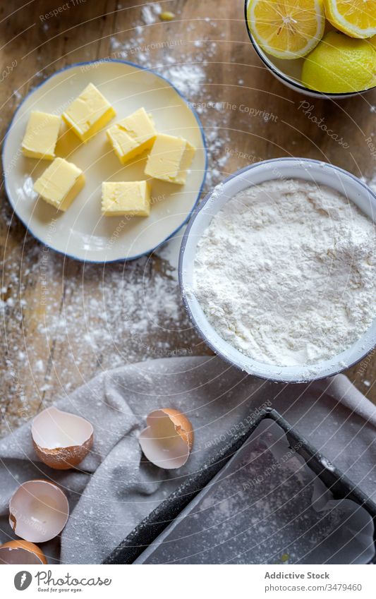Zutaten für Kuchenrezept auf dem Tisch mit Mehl gepudert Bestandteil Butter Rezept Eier backen Zitrone Lebensmittel Vorbereitung Bäckerei selbstgemacht