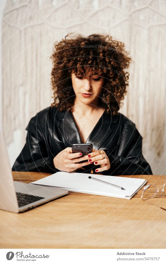 Vintage-Unternehmerin mit Smartphone, die sich Notizen macht Geschäftsfrau Notebook Büro benutzend retro Jacke Arbeit Frau Laptop Gerät Leder Apparatur