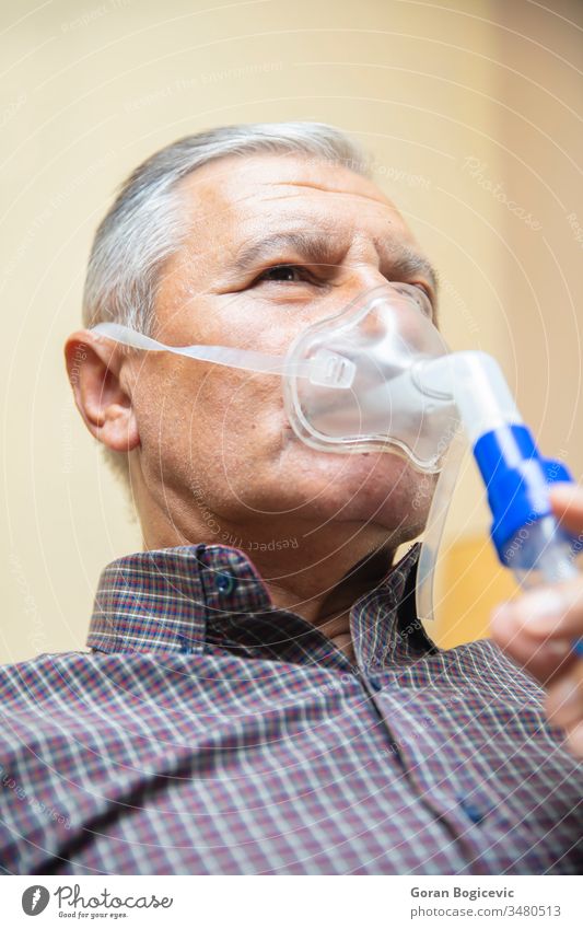 Älterer Mann mit medizinischer Ausrüstung zur Inhalation mit Atemmaske, Vernebler Aerosol Air Allergie Asthma Asthmatiker Atmung bronchiale Bronchitis Pflege
