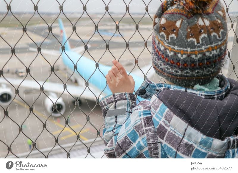 Kind am Zaun der Fluhafenabsprerrung mit Blick auf ein Flugzeug auf dem Flugfeld Mensch Ferien & Urlaub & Reisen Luftverkehr Himmel fliegen Außenaufnahme