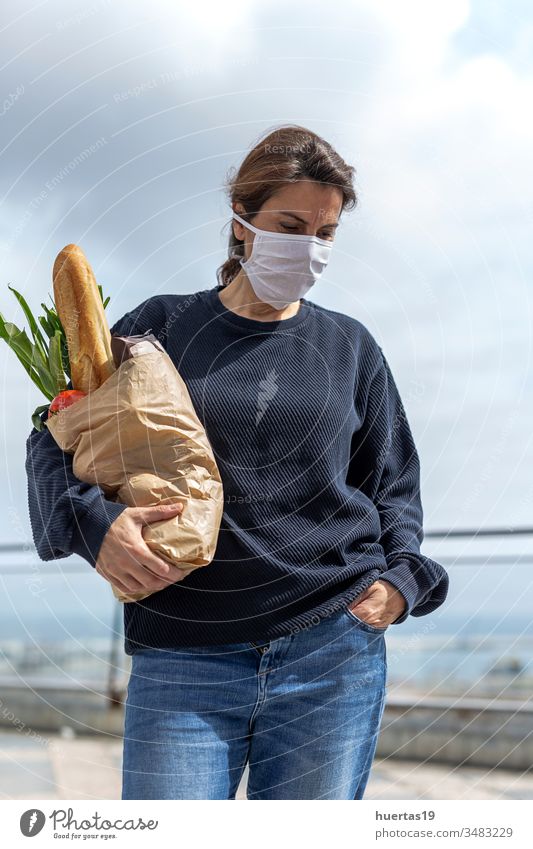 Frau mit Schutzmaske kommt mit dem Kauf nach Hause Coronavirus Mundschutz Pandemie Seuche Virus medizinisch Infektion Menschen behüten Großstadt covid-19