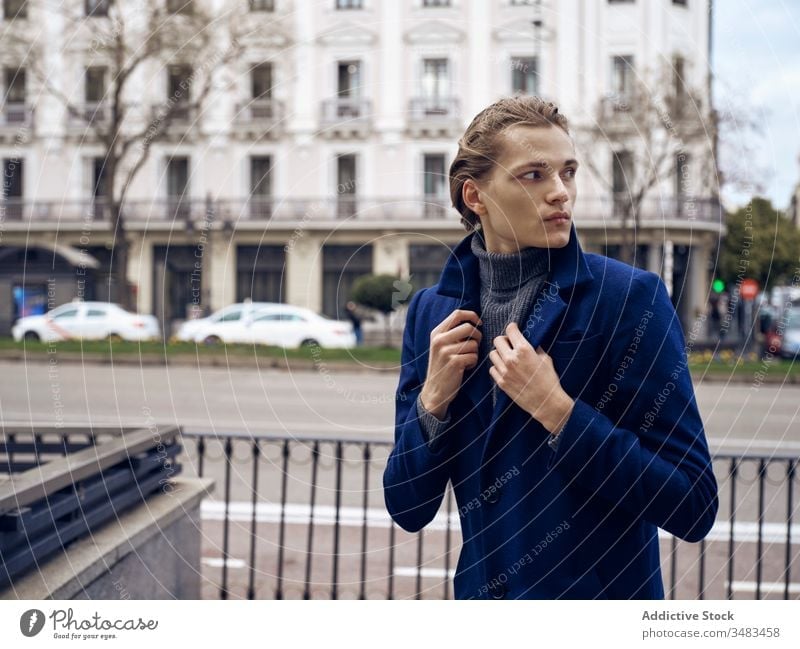 Selbstbewusster junger Geschäftsmann in trendigem Outfit steht auf der Straße Mann Stil trendy elegant Mode urban Mantel selbstbewusst ernst gutaussehend modern