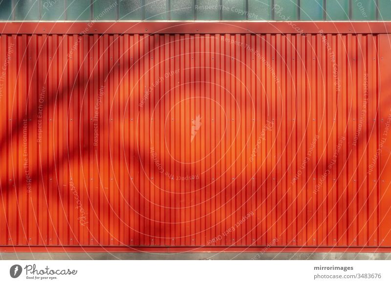 im Freien verwitterte vertikale rote Wand mit rotem Wandsiding im Hintergrund mit Baumschatten Seitengleis-Textur Metalltextur gerillt Leichtmetall industriell