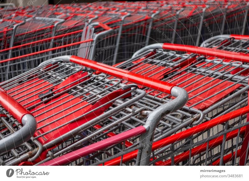 metallischer und roter Einkaufswagen Wagen in Reihe Einzelhandelskaufhaus Consumer Business-Konzept verschachtelt geparkt schieben Nahaufnahme Stapel Industrie