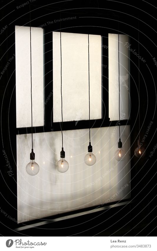 Glühbirnen, die vor einem alten Fenster hängen. Design weiß Metall Tür Wand Kraft elektrisch heimwärts Gerät vereinzelt Kasten Sicherheit Kontrolle Schaltfläche
