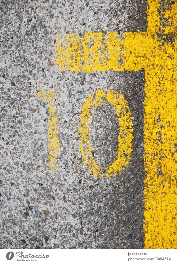 Nummer 10 neben Parkflächenmarkierung in gelb Symmetrie Bodenmarkierung Zahn der Zeit unten grau Linie einfach Strukturen & Formen Detailaufnahme