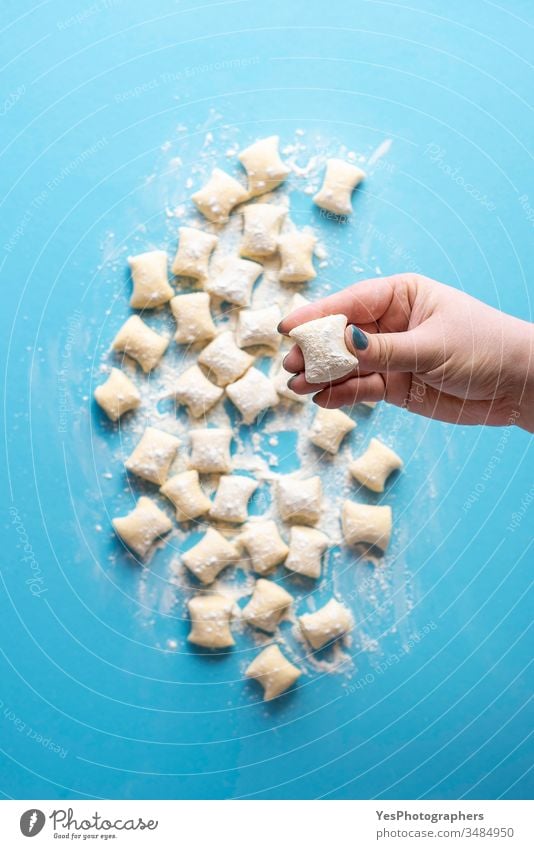 Käse-Gnocchi ungekocht in der Hand des Kochs. Haufen frischer Gnocchi-Knödel Italienisch obere Ansicht blau Essen zubereiten Küche Diät Abendessen Europäer