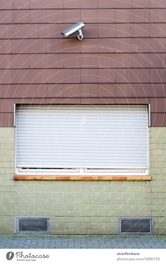 Mit Sicherheit - Fenster mit herabgelassenen Rolläden und einer Sicherheitskamera Haus Kamera verschlossen abweisend wohnen Wohngebiet Wand Fassade