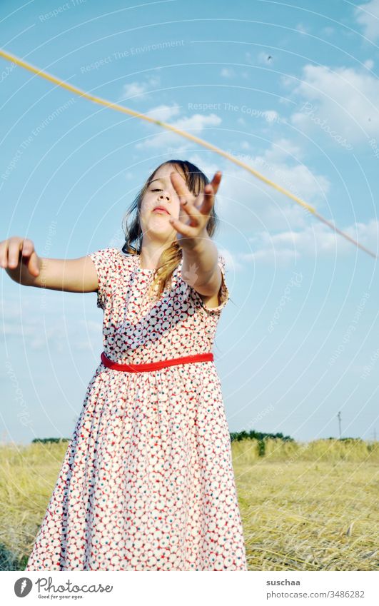 mädchen im sommerkleid greift nach einem strohhalm Kind Mädchen Sommer Feld Acker Sommerkleid fangen greifen Aktion nach dem Strohhalm greifen Symbol symbolisch