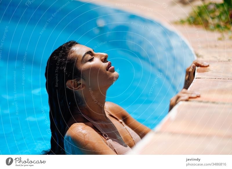 Schöne arabische Frau, die sich im Swimmingpool entspannt. Pool Schwimmsport Sommer schön Bikini jung Wasser Mädchen Sonnenbad Schönheit Körper attraktiv sonnig