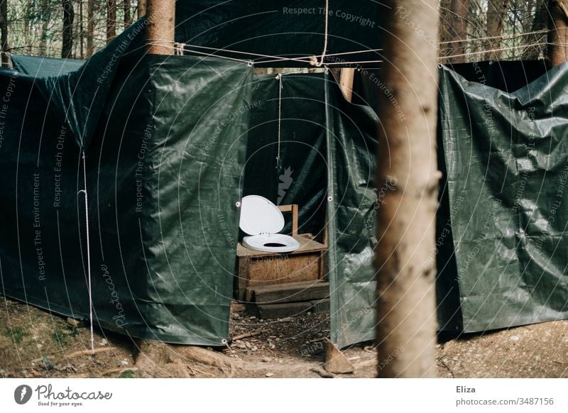 Eine Outdoor Toilette mit Planen geschützt draußen im Wald; Camping, Ferienlager, Plumpsklo, Klo outdoor zelten Menschenleer Farbfoto Außenaufnahme Natur