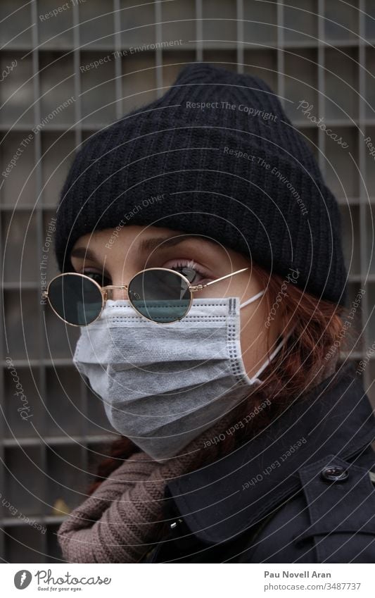 Nahaufnahme einer Frau, die ihr Gesicht mit einer Schutzmaske bedeckt. Virus-Konzept medizinische Ausrüstung Gesichtsmaske Seuche Coronavirus schützend