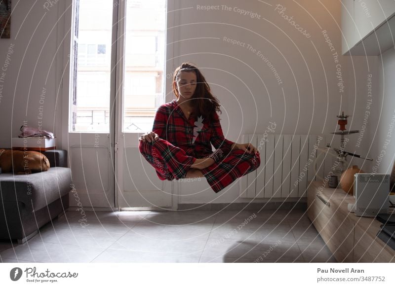 Junge Frau mit Pijama meditiert, während sie zu Hause schwebt Harmonie fliegend Spiritualität Kontemplation jung Konzentration Fliege Meditation sexy