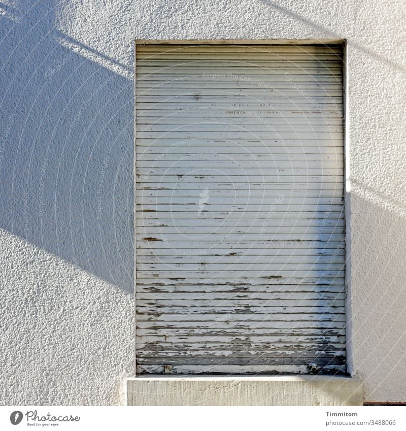 Licht und Schatten mit Rolladen Fassade Gebäude alt beschädigt Fenster Architektur Haus trist Sonnenlicht grau