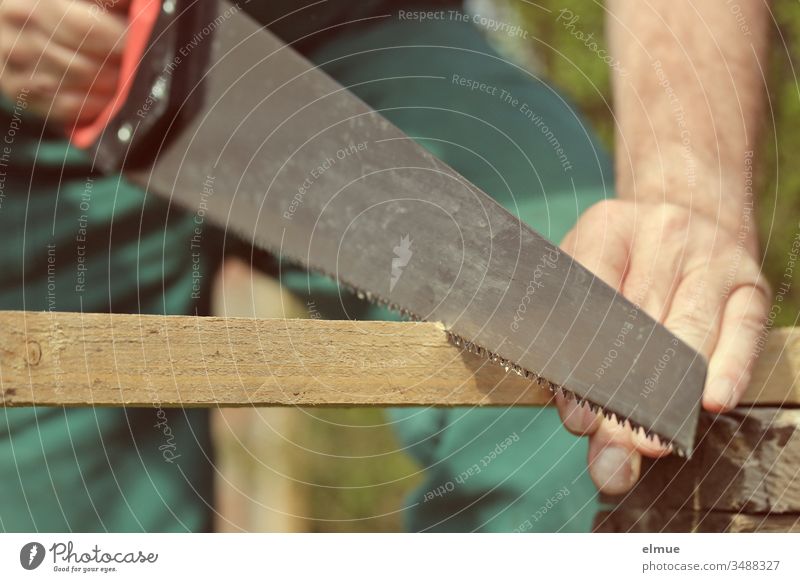 Mann sägt mit Fuchsschwanz eine Holzlatte durch - Ausschnitt Säge Werkzeug Arbeitsschutz sägen Handwerker to it yourself Latte arbeiten Freizeit & Hobby