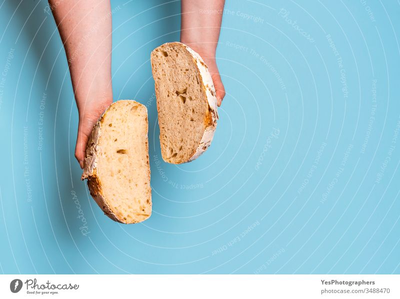 Sauerteigbrot in zwei Scheiben geschnitten vor einem blauen Hintergrund. obere Ansicht backen gebacken Bäckerei Brot backen Blauer Hintergrund Brot im Inneren