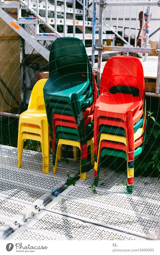 ein stapel bunter stühle Stuhl Stühle Stapel stapelbar draußen Veranstaltung Plastikstuhl Event rot gelb grün Farbfoto Menschenleer Außenaufnahme Tag