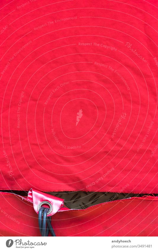 Eine zerknitterte rein rote Plane mit einem Loch und einem Loch abstrakt Kunst Zusammenhalt Hintergrund Hintergründe Plakatwand blanko Leinwand übersichtlich