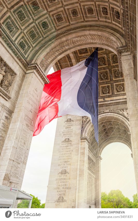 Blick auf den Arc de Triomp mit der im Wind wehenden französischen Flagge auf dem Place de Gaulle in Paris, Frankreich Bogen triumphieren Fahne Denkmal Europa