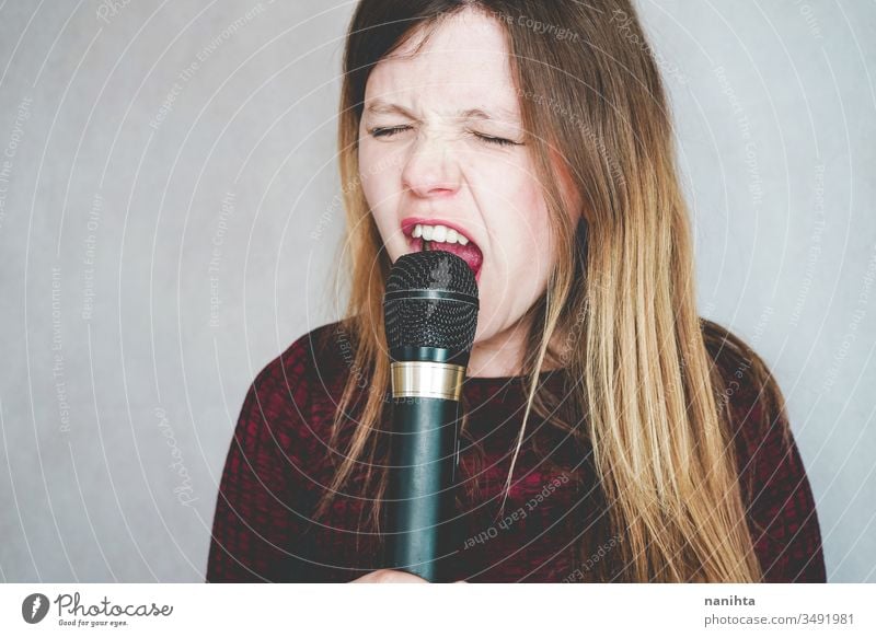 Junge Frau singt mit einem Mikrofon singen Gesang laut Technologie Klang Kunst Künstler Konzept Freizeit Aktivität aktiv blond lässig wirklich Menschen